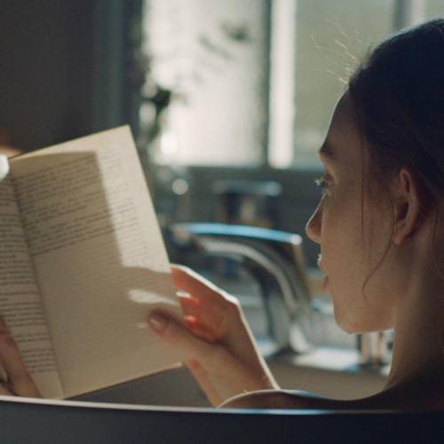 Kaya küvetinde kitap okuyan kadın